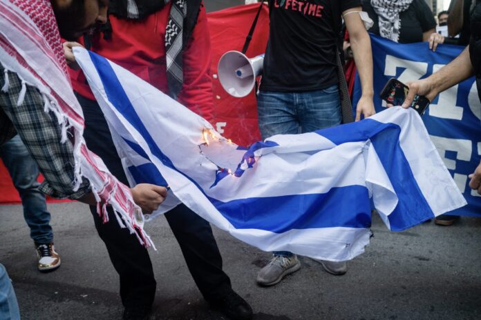 NEW YORK, UNITED STATES - May 15, 2021: Pro-Palestinian protesters burn Israeli flag in New York