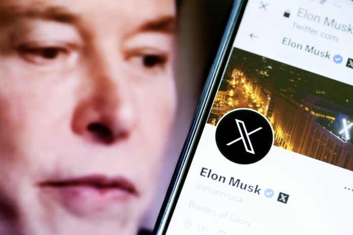 2023 Elon Musk's Twitter account page on a smartphone and Elon Musk in the background.
